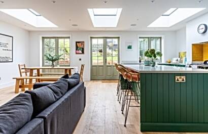 Triple set of timber French doors opening onto an open-plan kitchen and living space