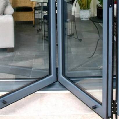 Detailed close-up of concertinaed grey aluminium bi-fold door frames