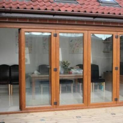 Oak-finish timber bi-fold doors opening into a dining room
