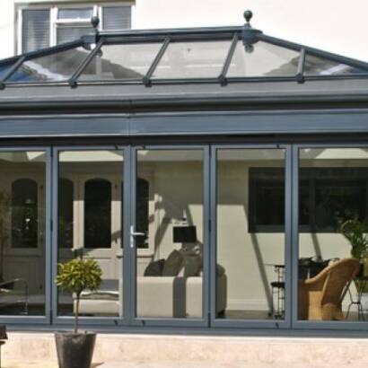 Anthracite grey aluminium bi-fold doors on a garden orangery with lantern roof